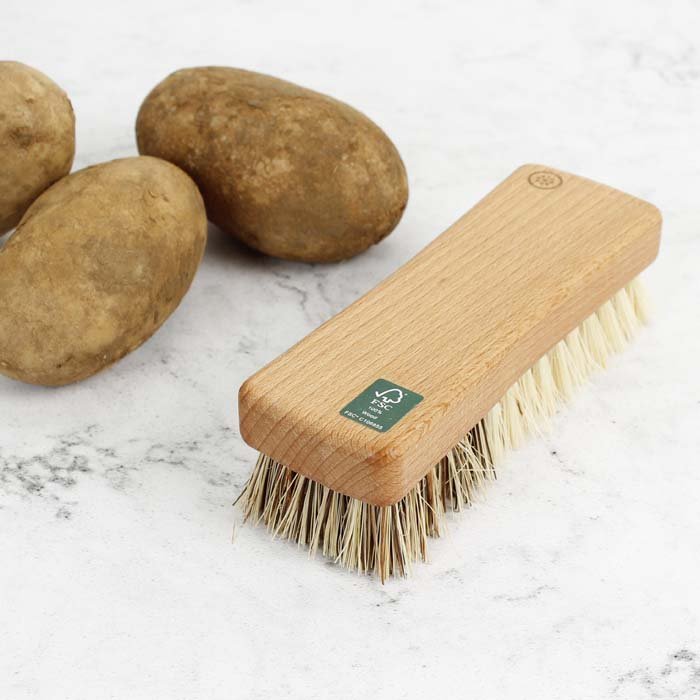 A Slice of Green Vegetable Brush — in use scrubbing potatoes