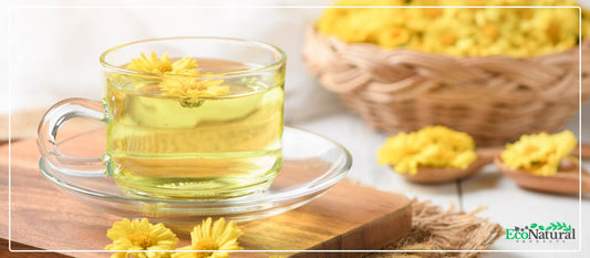 Chrysanthemum tea in a glass cup with fresh yellow flowers