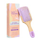 Detangling paddle hairbrush with purple bristles and wooden handle next to its packaging on a white background from brand Love Cocobo