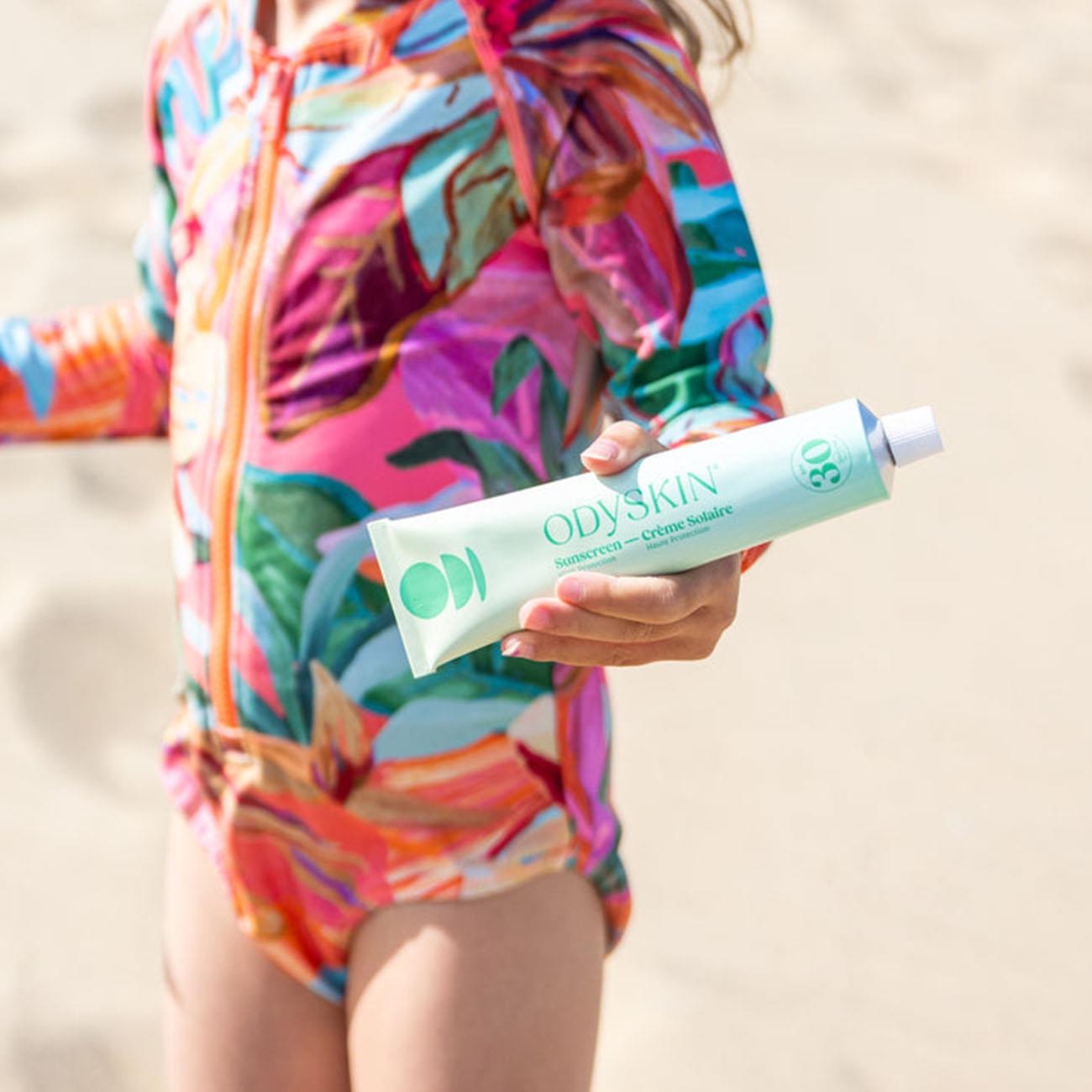 A kid holding Odyskin SPF30 sunscreen 